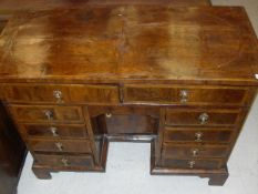 A walnut and feather-banded kneehole desk in the 18th Century manner,