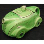An Art Deco style teapot in the form of a racing car in green glaze with silver lustre highlights