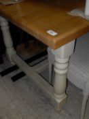 A modern stained beech farmhouse style kitchen table on cream painted base with centre stretcher