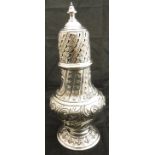 A Victorian silver sugar caster in the Georgian style with all over scrolling and foliate