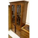 A mahogany display cabinet with two astragal glazed doors and fluted pilasters surmounted and