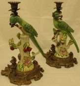 A pair of Continental candlesticks formed as parrots with brass mounts and bases