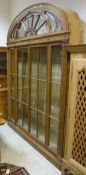 A 20th Century mahogany display cabinet in the Adam taste with a glazed fan fall front arch door to