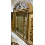 A 20th Century mahogany display cabinet in the Adam taste with a glazed fan fall front arch door to