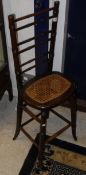 A Victorian stained beech framed and cane seated ladder back deportment chair of typical form,