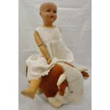 A Merrythought brown and white bull and an early 20th Century composition bodied doll,