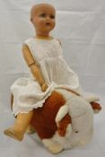 A Merrythought brown and white bull and an early 20th Century composition bodied doll,