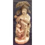 A Japanese Meiji period carved okimono as mother and children by a tree,