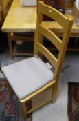 A modern beech rectangular kitchen table and set of seven panel seat ladder back chairs