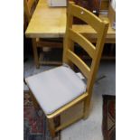 A modern beech rectangular kitchen table and set of seven panel seat ladder back chairs