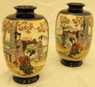 A pair of Japanese satsuma vases decorated with figures amongst trees,