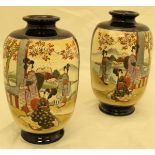 A pair of Japanese satsuma vases decorated with figures amongst trees,