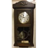 A 1930's oak cased drop dial wall clock with Arabic numerals