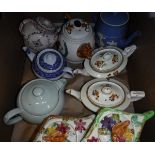 A box containing nine various decorative teapots