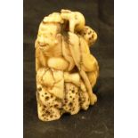 A 19th Century Japanese Meiji period carved ivory netsuke as Sennin seated on rocks,