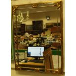 A rectangular wall mirror with a mirrored frame and mouldings to the corners