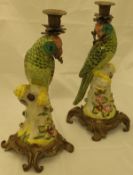 A pair of Continental pottery candlesticks modelled as parrots,