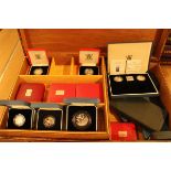 A box containing a collection of 33 small cases of commemorative silver proof coinage