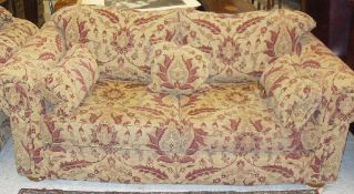 A pair of Multiyork terracotta on gold floral decorated scroll arm sofas and matching stool