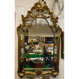 A 20th Century wall mirror in the Rococo taste, the frame finished in a gold coloured paint,