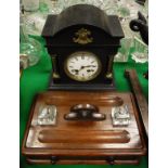 A black slate Victorian mantle clock, the Roman numerals to the enamelled dial,