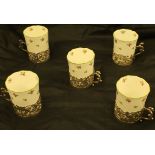 A set of five decorated porcelain coffee cans with silver pierced scrolling foliate cherubic