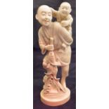 A Japanese Meiji period carved ivory okimono as a fisherman and young child upon his shoulders,