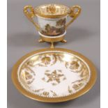 A Derby double handled cabinet cup and saucer, the cup with continuous landscape of harbour, church,