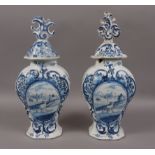 A PAIR OF MID 18TH CENTURY DUTCH DELFT VASES, each with domed covers, scroll finials,