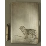 A cigarette case in silver engraved to the front with the portrait of a springer spaniel with