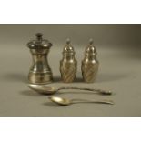 A pair of late Victorian silver pepperettes, Birmingham 1892, of wrythen form, with domed covers,