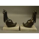 A pair of continental Art Deco bronzed spelter bookends in the form of pelicans, with glass eyes,