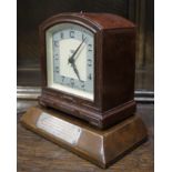 A 1940s brown Bakelite cased electric clock by Smiths together with a presentation plinth with