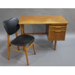 A teak desk with two integral drawers with bar handle and slide, on rounded legs,