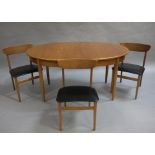A 1970s teak oval dining table and three bar back chairs