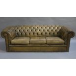 An olive green leather chesterfield sofa, c.