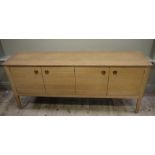 A Gordon Russell oak sideboard of four doors with circular and bar handles, on square tapered legs,