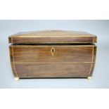 A Regency mahogany tea caddy the shallow shaped lid centred on an inlaid rectangle opening to