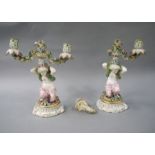 A pair of English porcelain floral encrusted figural two branch candlesticks,