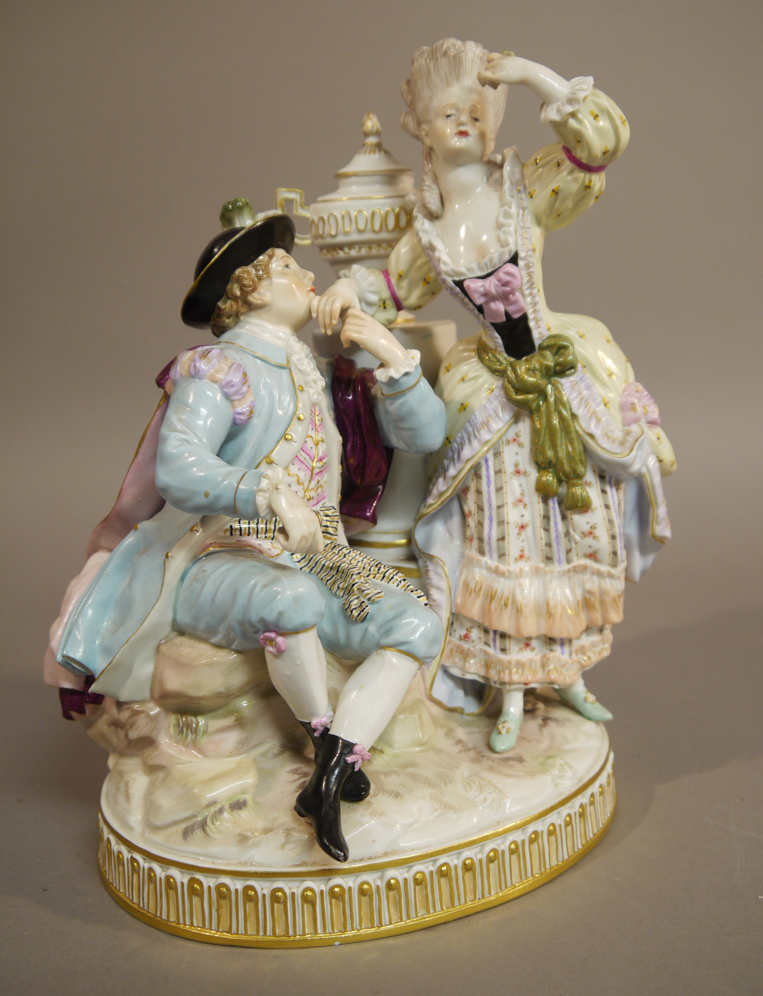 A Meissen porcelain figure group finely modelled with a courting couple before a pedestal with urn,