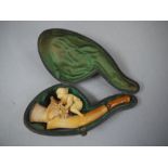 A late 19th century meerschaum pipe the bowl finely carved with a young boy and leafage