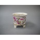 An English porcelain inkwell of cylindrical form, the body painted with primroses,