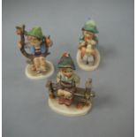 Three Hummel figures; boy on fence, boy with chick on his feet and boy in branch, 9cm high,