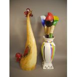 A novelty chicken and a novelty vase with three large brushes,