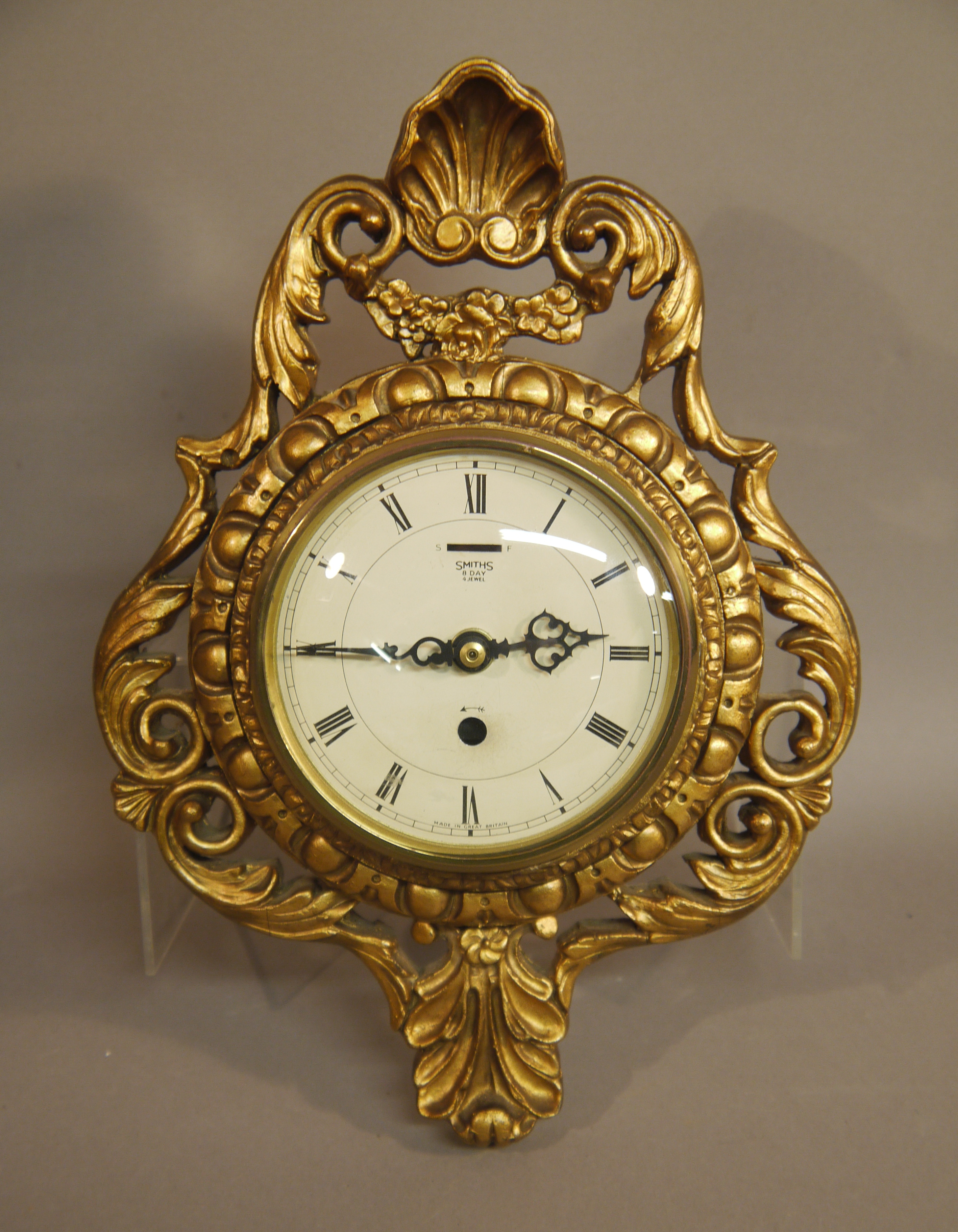 An Atsonia cartouché clock with cream enamelled dial with Roman numerals inscribed Smith's eight