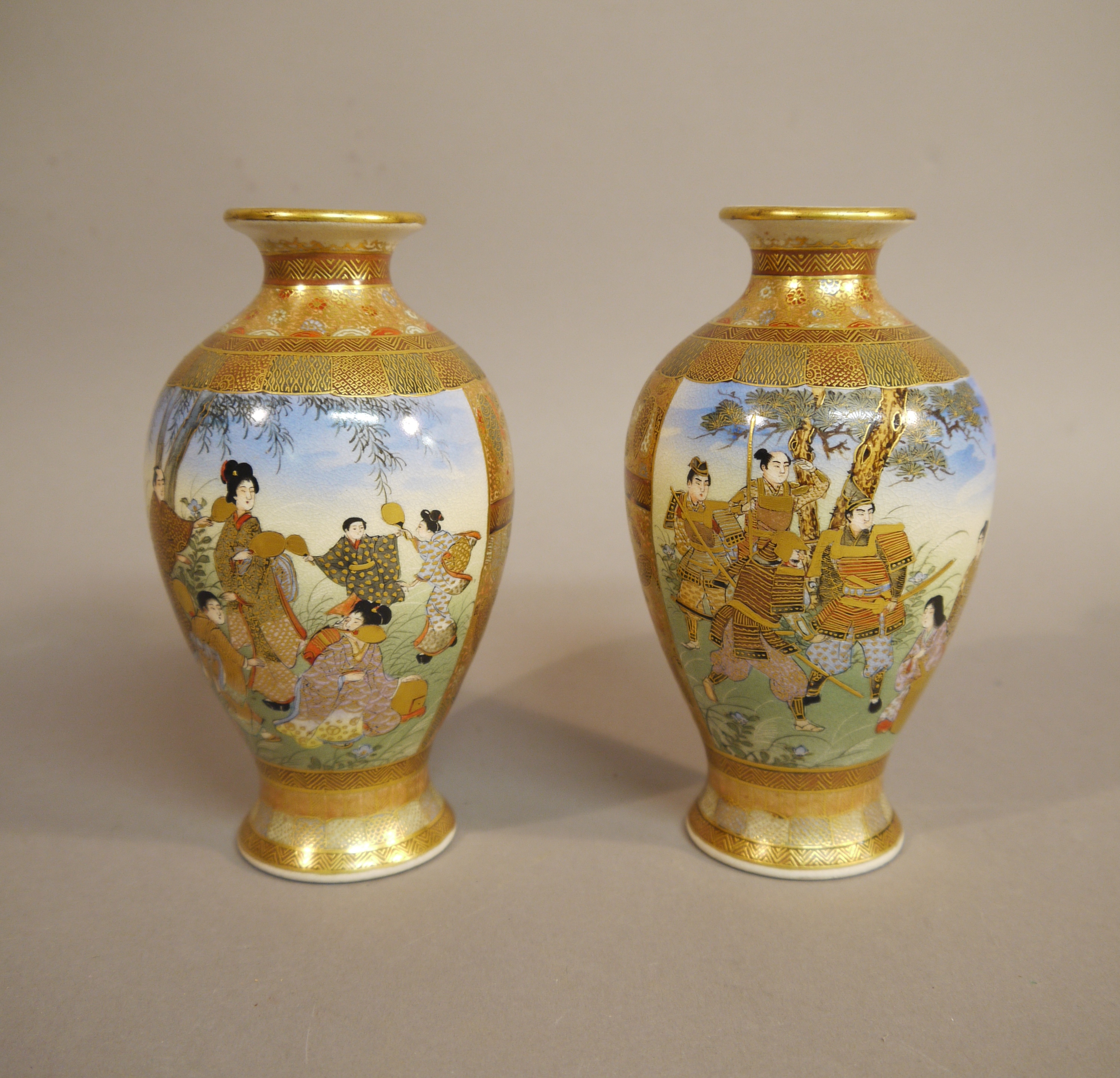 A good pair of Japanese satsuma pottery baluster vases each painted with two panels,