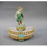 A Victorian majolica basket with infant figure holding a dish above a 'D' shaped basket with