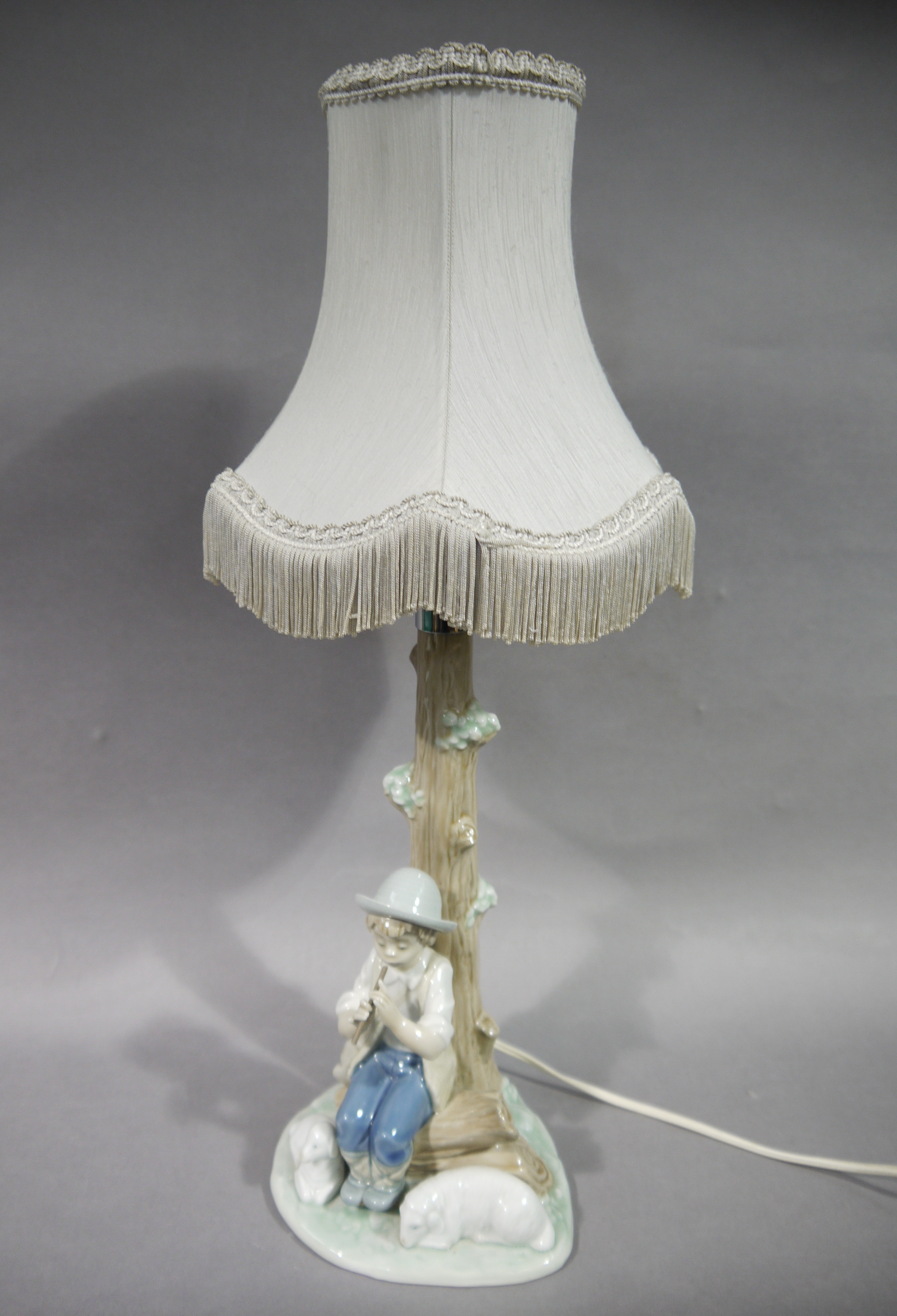 A pair of porcelain Nao table lamps, one modelled as a female seated with rabbits, - Image 2 of 2