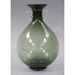 An art glass two handled green glass vase of baluster form with clear glass strapwork handles,