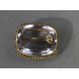 A George IV set brooch in 15ct gold the cushion shaped faceted stone collet set within a convex